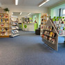 Blick auf die Theke in der Bibliothek Schönefeld im Eingangsbereich aus dem Bereich für AV-Medien.