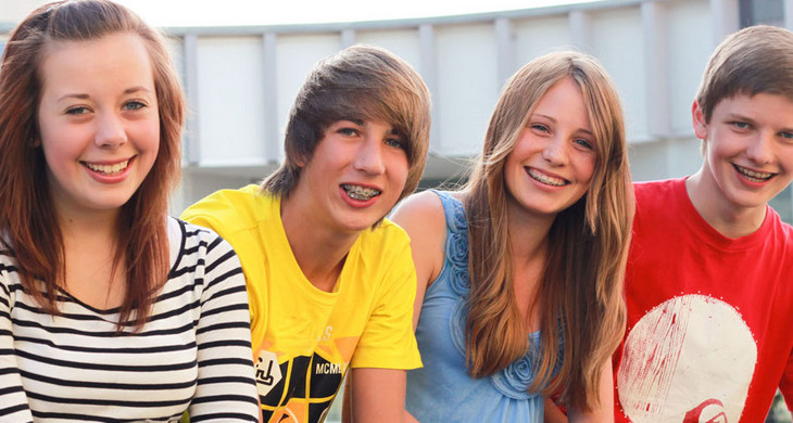 Zwei Jungen und zwei Mädchen lächeln in die Kamera.
