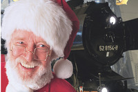 Porträt des Weihnachtsmanns vor historischer Dampflok
