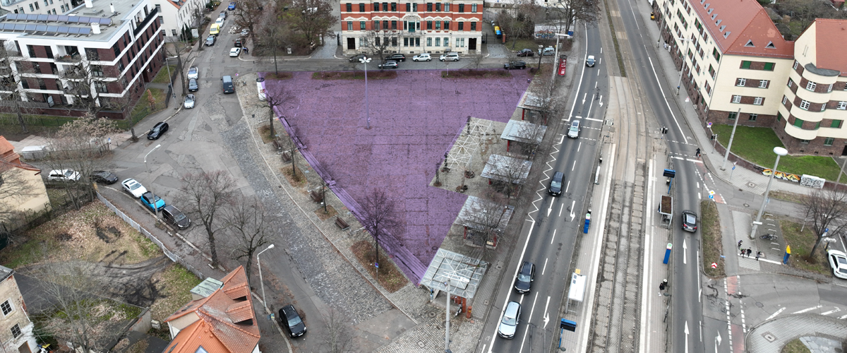 Der Eutritzscher Markt ist aus Luftperspektive aufgenommen. In dreieckiger Form von drei Straßen umfasst wird durch eine lila Fläche, welche nachträglich in das Foto eingetragen wurde, die potentielle Aktionsfläche gekennzeichnet.